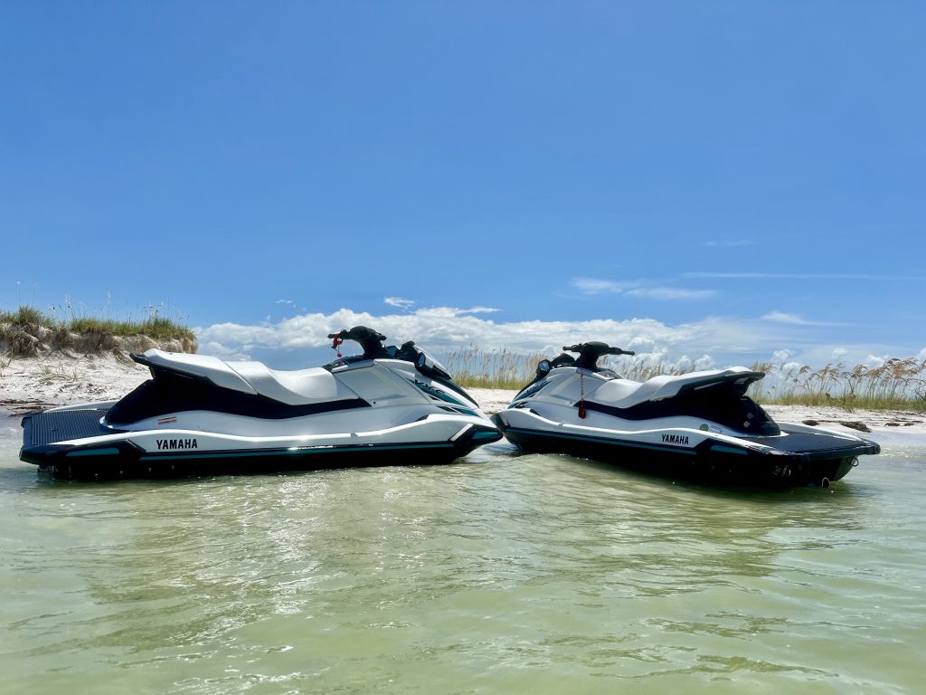 Jet skis lined up on the sandy beach in Tampa Bay, ready for rental with Southern Dreams Watersports.